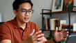 © Anna - Professional Asian man on a video conference call from his home office. Male employee talking and gesturing during a virtual meeting
