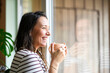 © Louis-Paul Photo - Happy relaxed woman enjoying quiet time with coffee close to a window