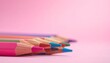 © Pulse - Sharpened colored pencils in vibrant hues pointing forward with dreamy pink-purple bokeh background.