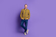 © deagreez - Young handsome guy in checkered plaid shirt posing against purple background for fashion lifestyle advertising and stock photo on sale