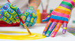 © aziz - Children's Hands Painted with Bright Colors Drawing a Yellow Circle