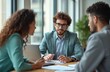 © miss irine - Financial expert consults with young diverse couple in office. They discuss plans, review documents with laptop and papers on table. Professional meeting for future.