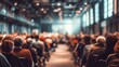 © li - Conference Audience Blur: A blurred background of an audience at a conference or seminar, with rows of seats and people listening attentively. High quality