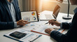 © AucArtStudio - professionals review chart and graph report on tablet and paper during meeting showing growth concern and strategic planning