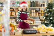 © JackF - Female vendor in a Santa Claus hat offers to buy nougat for the festive table on Christmas