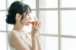 © buritora - Asian woman drinking red drinks in the morning at home (tomato juice, red smoothie, acerola juice)