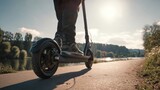 Person Riding Electric Scooter Along Scenic Pathway by River at Sunset in Vibrant Nature Setting