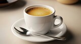 White cup of coffee on a saucer with a spoon