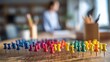 © Dcelup - Colorful Push Pins Arrayed on Wooden Desk, Blurred Office Background.