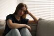 © New Africa - Depressed teenage girl on sofa at home