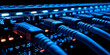 © watz - Close-up of blue Ethernet cables plugged into a dark server rack with illuminated indicator lights.