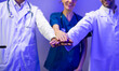 © NVB Stocker - Doctors and nurses stacking hands together. Portrait of Professional Healthcare staff Team. Male and female Doctor and nurses medicals staff. Professionalism successful teamwork and Unity