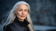 © Maksym - Confident older woman with long silver hair styled effortlessly, black outfit contrasting against a matte dark backdrop, illuminated by soft rim light for cinematic mood