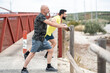 © Antonio Recena - A 65-year-old man and his 40-year-old son warm up and stretch their muscles before going for a run.