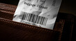 © Platon - Baggage tag with barcode peeking out of a leather wallet.A dark, close-up, and high-contrast photograph showing a white paper airline baggage ticket (labeled 'Baggage Ticket')
