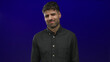 © Krakenimages.com - Young hispanic man wrinkles nose and scrunches face in a vivid deep blue studio setting wearing a dark shirt; raw disgust.