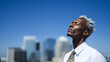 © Yuparet - Confident business owner standing on rooftop with eyes closed, enjoying sunlight and fresh air, modern cityscape background, blue sky, peaceful and relaxed expression