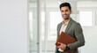 © Shivani - Smiling Indian Businessman Holding Portfolio in Modern Office