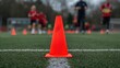 © CryptoCanvas - Red cone positioned on the ground during training exercise, focus on agility and coordination