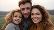© Bussakon - A happy family of three smiles warmly embracing outdoors during the soft light of golden hour