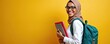 © Viktor - Happy black girl student in headscarf, glasses, backpack. Holds books, notebooks. Young African American muslim woman smiles, stands on yellow studio background. Ready for college, university