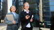 © muse studio - Two women in business attire walking downtown