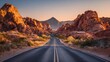 © Linda - A desert road stretches through canyons and towards a mountain under an orange-toned sky