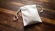 © Patti - elevated view of a blank white pouch on a rustic timber surface for versatile applications