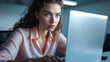 © Bernd Schmidt - Focused woman working laptop professional modern office pastel pink blouse natural light concentration serious expression serene generative AI