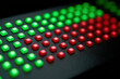 © Nakarin - Programmable LED control panel glowing softly in red and green lights on black surface with square buttons