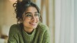 © Khawla - Smiling Indian Woman in Green Sweater by Window