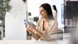 © fizkes - Happy young Latin businesswoman typing on smartphone at office workplace