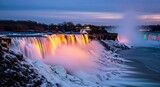 Niagara Falls illuminated at twilight, cascading water, snow, long exposure