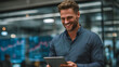 © CinimaticWorks - young business man working in office holding digital tablet reviewing online finance data productivity innovation and successful professional lifestyle
