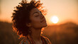 © CinimaticWorks - black woman with closed eyes enjoying warm sunset glow in the fields as backlit sunlight highlights her calm smile expressing peace emotional warmth and a beautiful outdoor moment