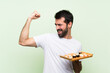 © luismolinero - Young handsome man with sushi over isolated green wall celebrating a victory