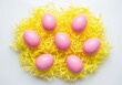 © Meow Creations - Seven smooth pink easter eggs nestled in a bright yellow decorative paper nest.