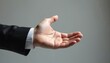 © miss irine - Businessman in black suit, white shirt cuff extends open hand palm. Gesture conveys inviting, offering, requesting, giving, taking. Suggests asking for cooperation, presenting concept, showing