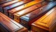 © Eza - A close-up view reveals a collection of polished wooden caskets arranged in neat rows. Various wood grains and finishes are evident