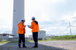 © Freeday photo - Workers inspect wind turbines and manage equipment at a renewable energy site in a sunny landscape with blue skies