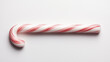 © Vladyslav - Candy cane lying on a white surface, showcasing red and white stripes in a festive arrangement