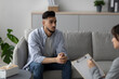 © Prostock-studio - Young Arab man appears distressed while discussing his depression with a counselor in a clinic office. The setting is calm and supportive, focusing on mental health treatment.