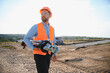© Serhii - Surveyor engineer carrying land surveying equipment at construction site