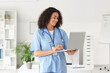 © Pixel-Shot - Female African-American medical student using laptop in office