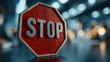 © Oulaphone - A close-up of a red stop sign with raindrops, set against a blurred background of lights, emphasizing its importance as a warning.