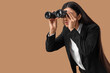 © Pixel-Shot - Young businesswoman looking through binoculars on beige background. Search concept