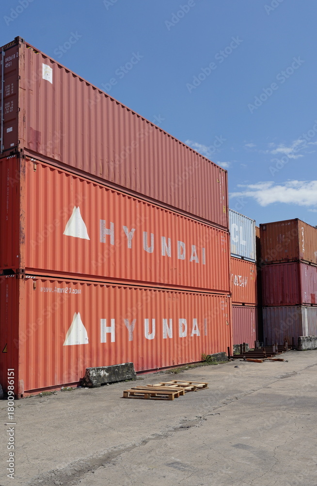Towering vertical stacks of vibrant cargo shipping containers stand on ...