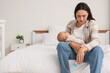 © Pixel-Shot - Young mother with bottle and her baby suffering from postnatal depression in bedroom