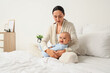 © Pixel-Shot - Young mother with her baby suffering from postnatal depression in bedroom