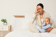 © Pixel-Shot - Tired mother with her baby suffering from postnatal depression in bedroom